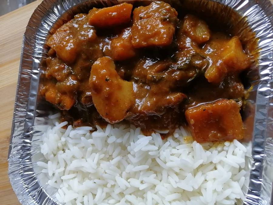 Curry with white rice in a takeaway tray